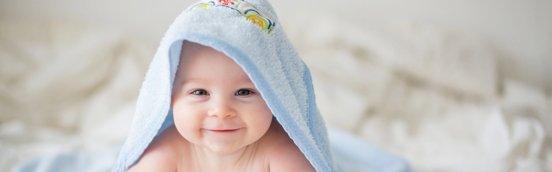 uśmiechnięte niemowlę z ręcznikiem na głowie